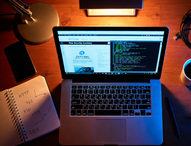 Beginner ethical hacker desk setup with PortSwigger Web Security Academy open on laptop